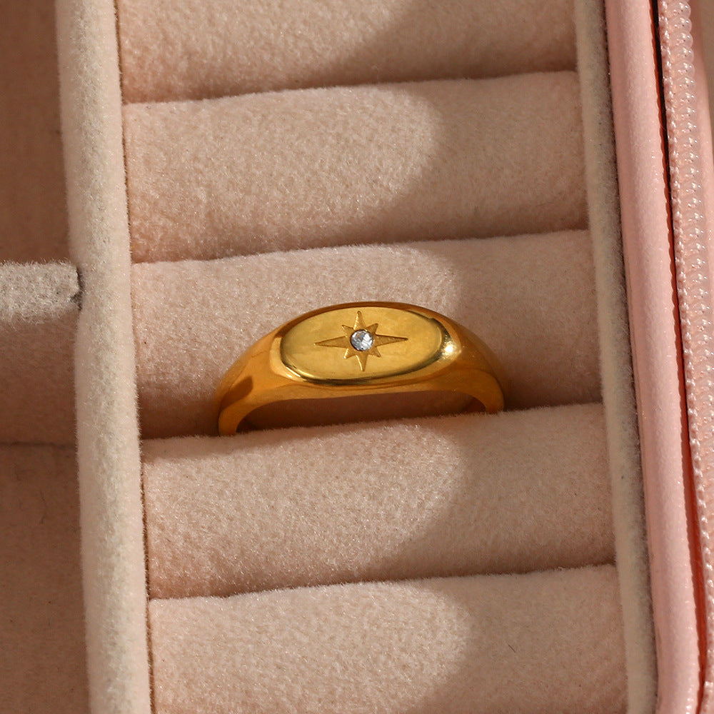 gold plated oval starburst signet ring displayed in a jewelry box