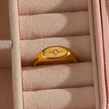 gold plated oval starburst signet ring displayed in a jewelry box