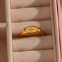gold plated oval starburst signet ring displayed in a jewelry box