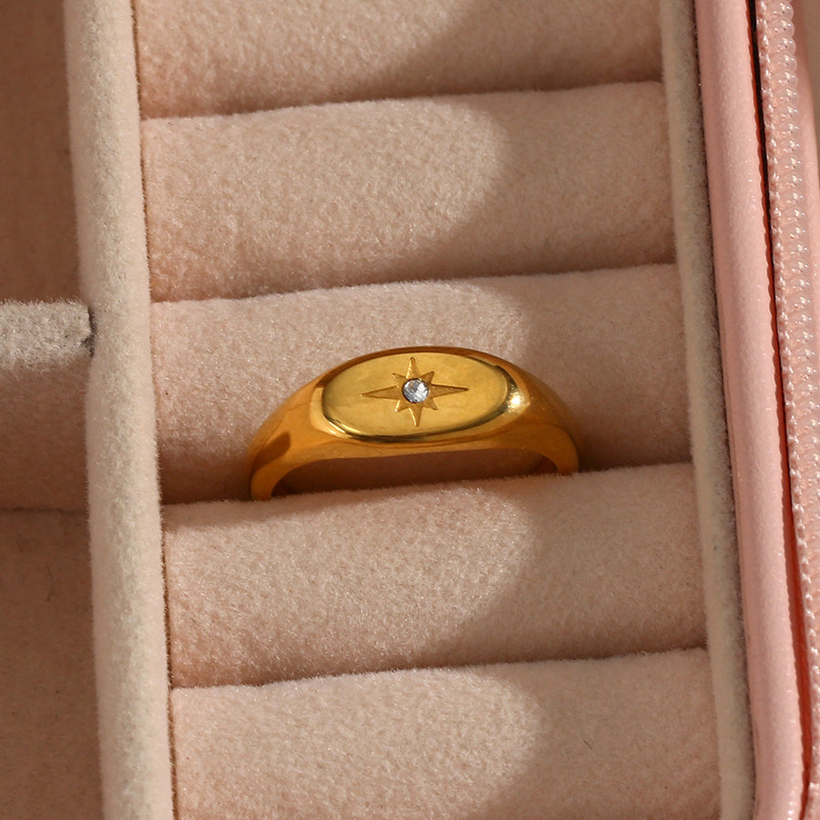 gold plated oval starburst signet ring displayed in a jewelry box