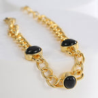 close view of three black agate settings on twin curb-link chains