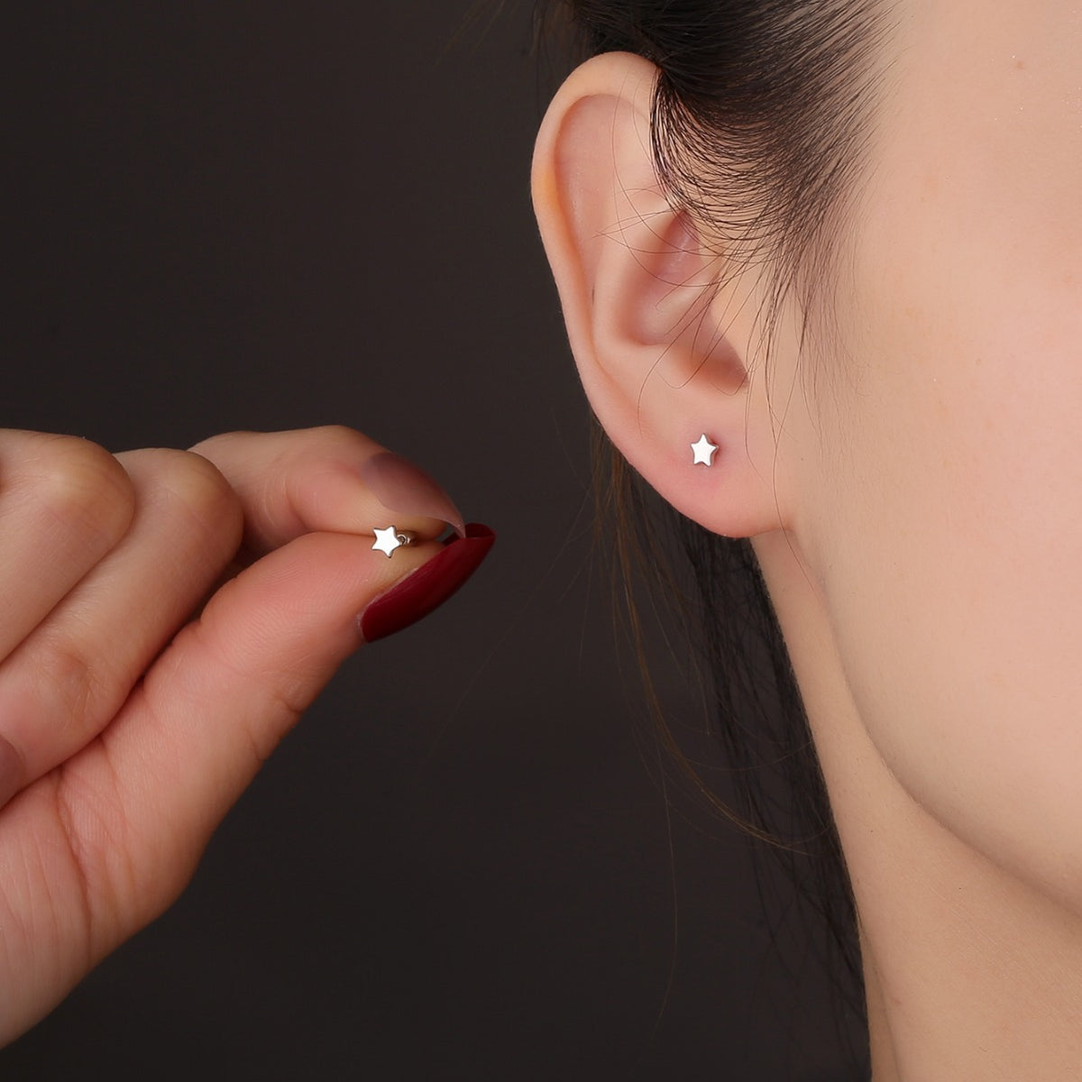 small polished silver star ball-back stud worn on the ear