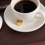 gold plated stainless steel wave ring beside a coffee cup