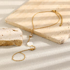 White and clear accent foot chain arranged on stone