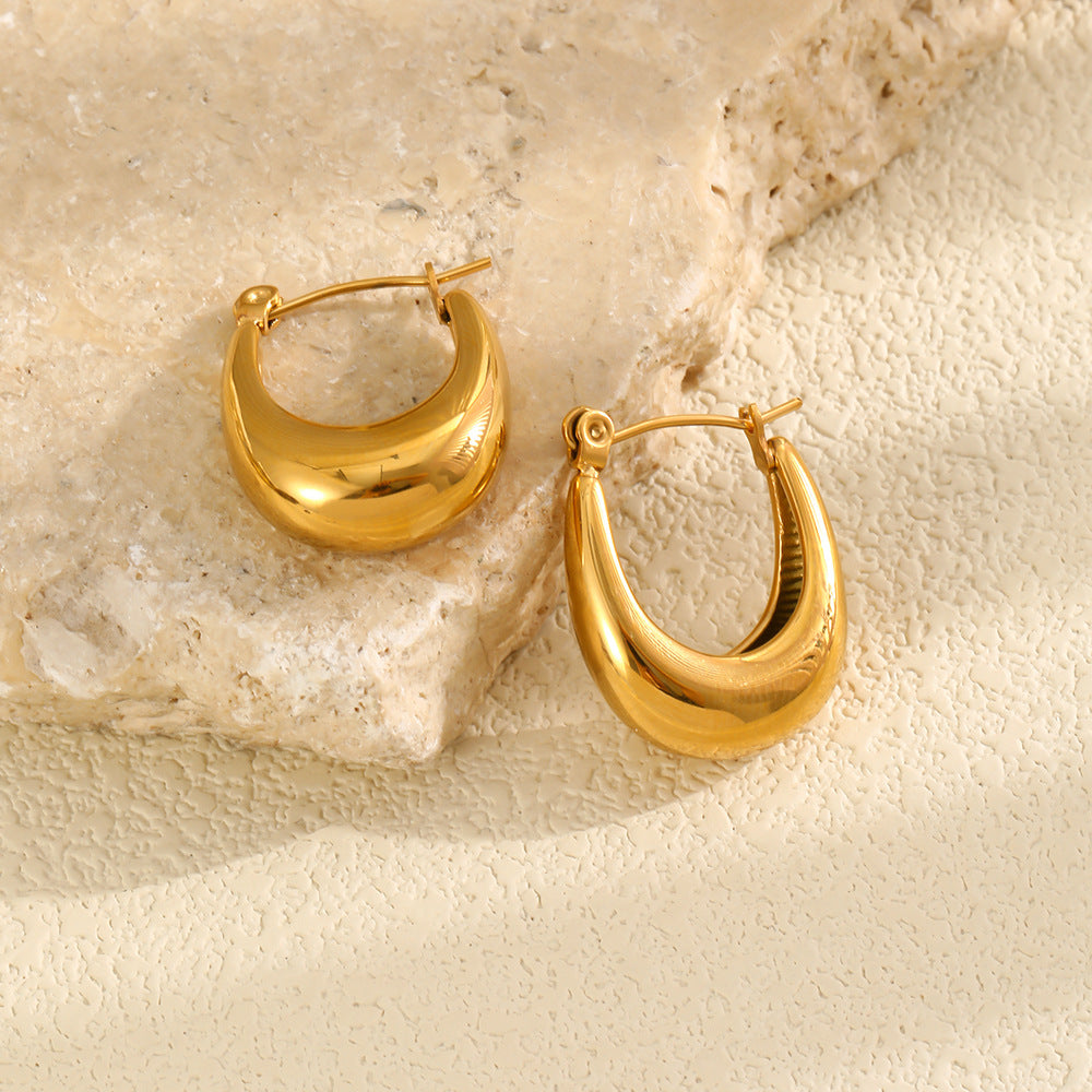 Gold plated U-shaped hoops resting on stone