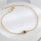 angled view of fine-chain evil eye bracelet with blue center stone
