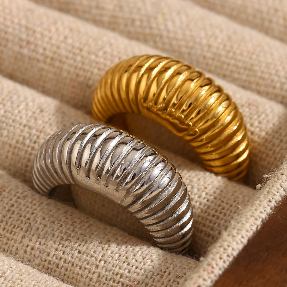 gold and silver ribbed tapered dome rings on textured fabric