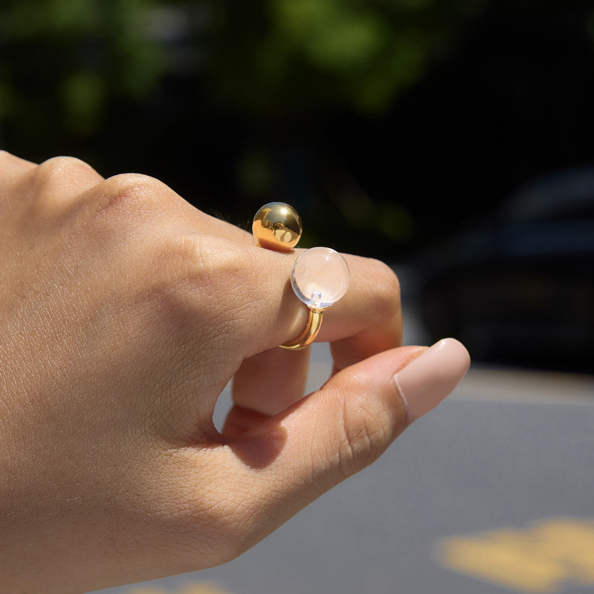 Clear resin ball ring shown in sunlight on a finger