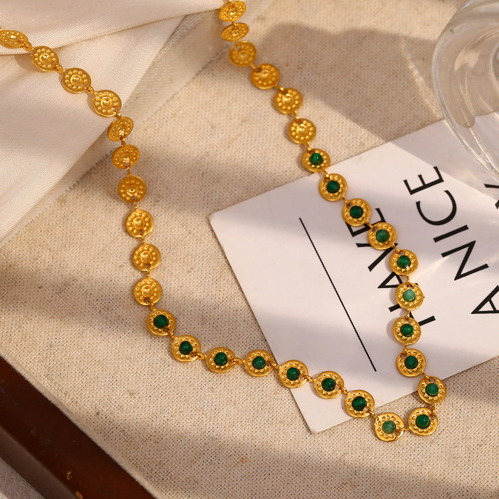 close view of repeating textured medallions and round green stones