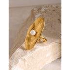 Gold plated oval disc ring with off-center white bead