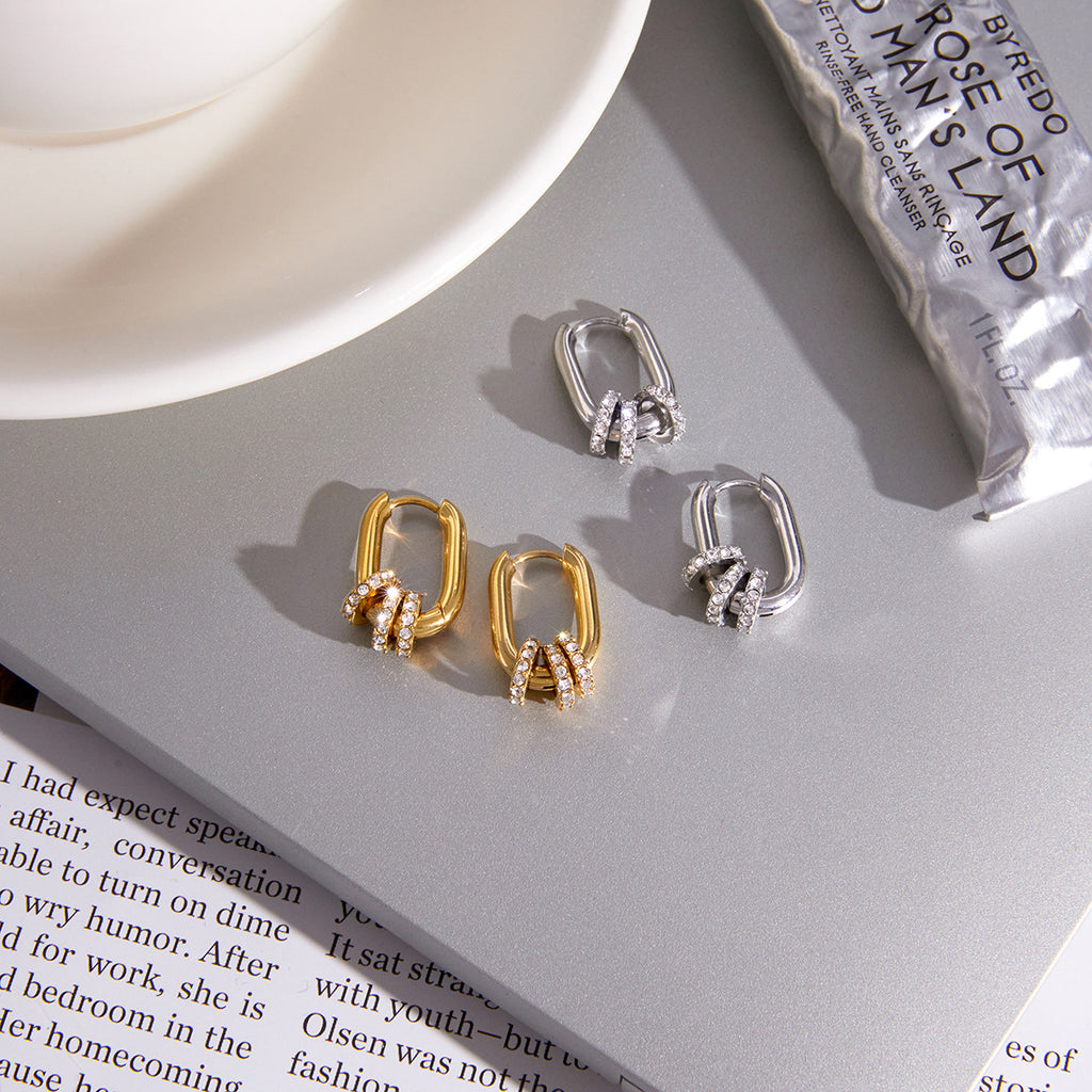 Gold and silver-colored oval charm hoops displayed together