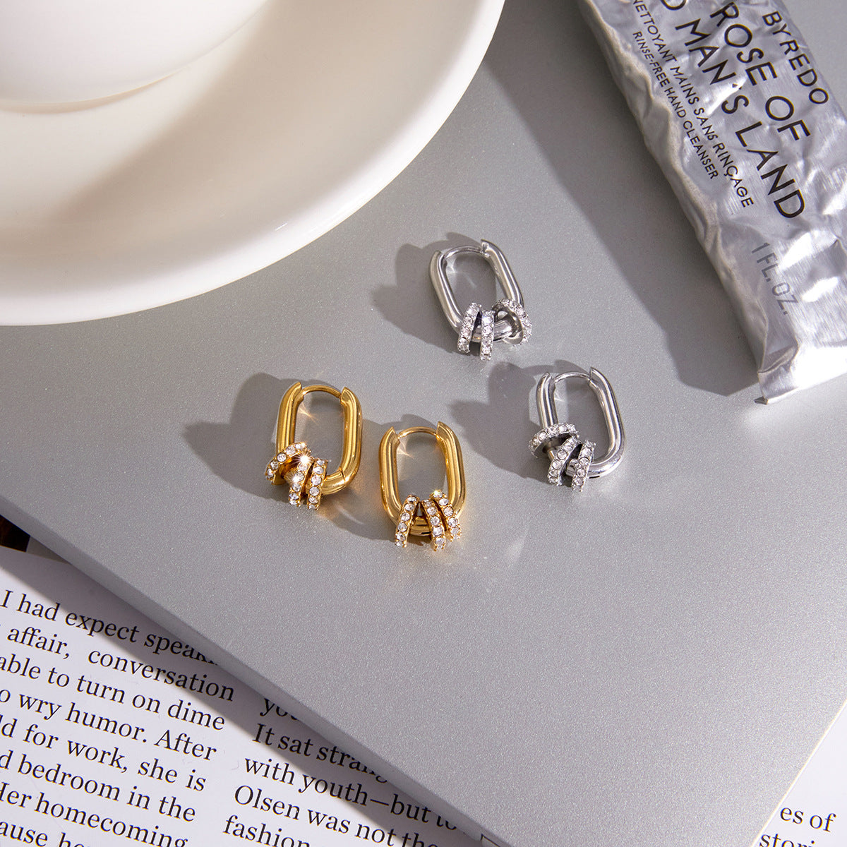 Gold and silver-colored oval charm hoops displayed together