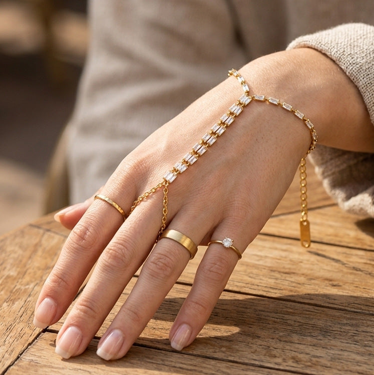 Clear stone hand chain worn with rings