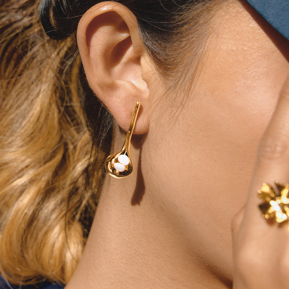 gold plated calla lily freshwater pearl earring worn on ear