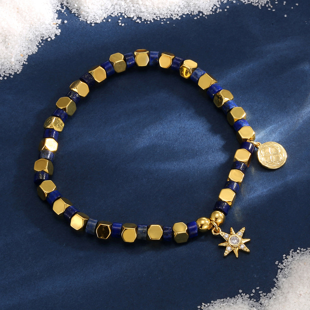 dark blue and gold beaded charm bracelet on navy fabric
