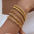Five stainless steel chain bracelets layered on a wrist