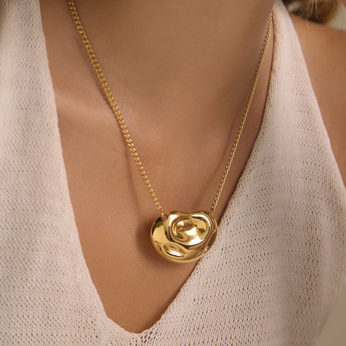 Single swirl pendant necklace worn at neckline