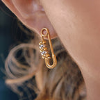 two-tone stainless steel safety-pin earrings worn on ear
