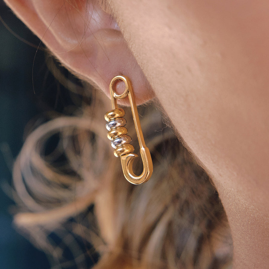 two-tone stainless steel safety-pin earrings worn on ear