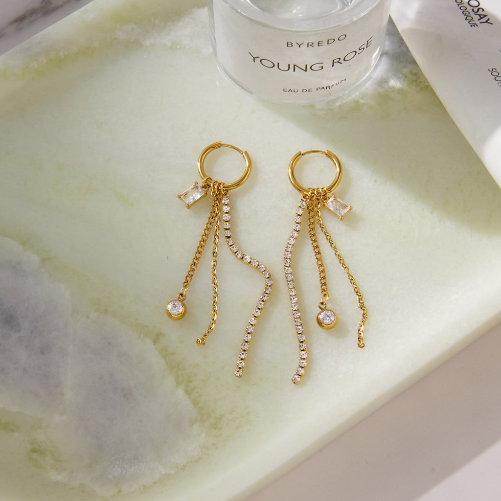 Pair of fringe earrings laid on a pale surface