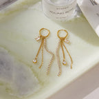Pair of fringe earrings laid on a pale surface