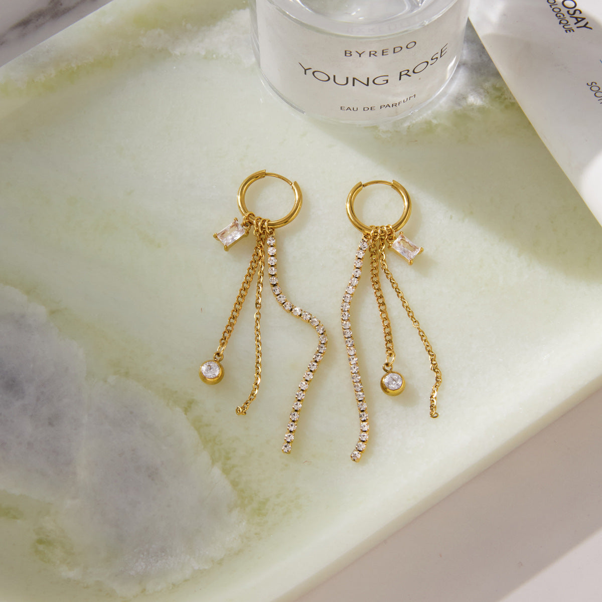 Pair of fringe earrings laid on a pale surface