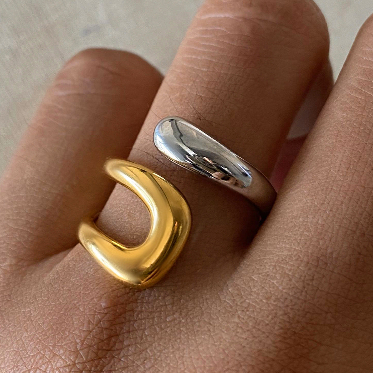 Two-tone sculptural stainless steel open ring worn on a finger