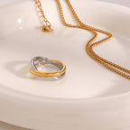 Gold detail crossing a silver-colored stainless steel ring