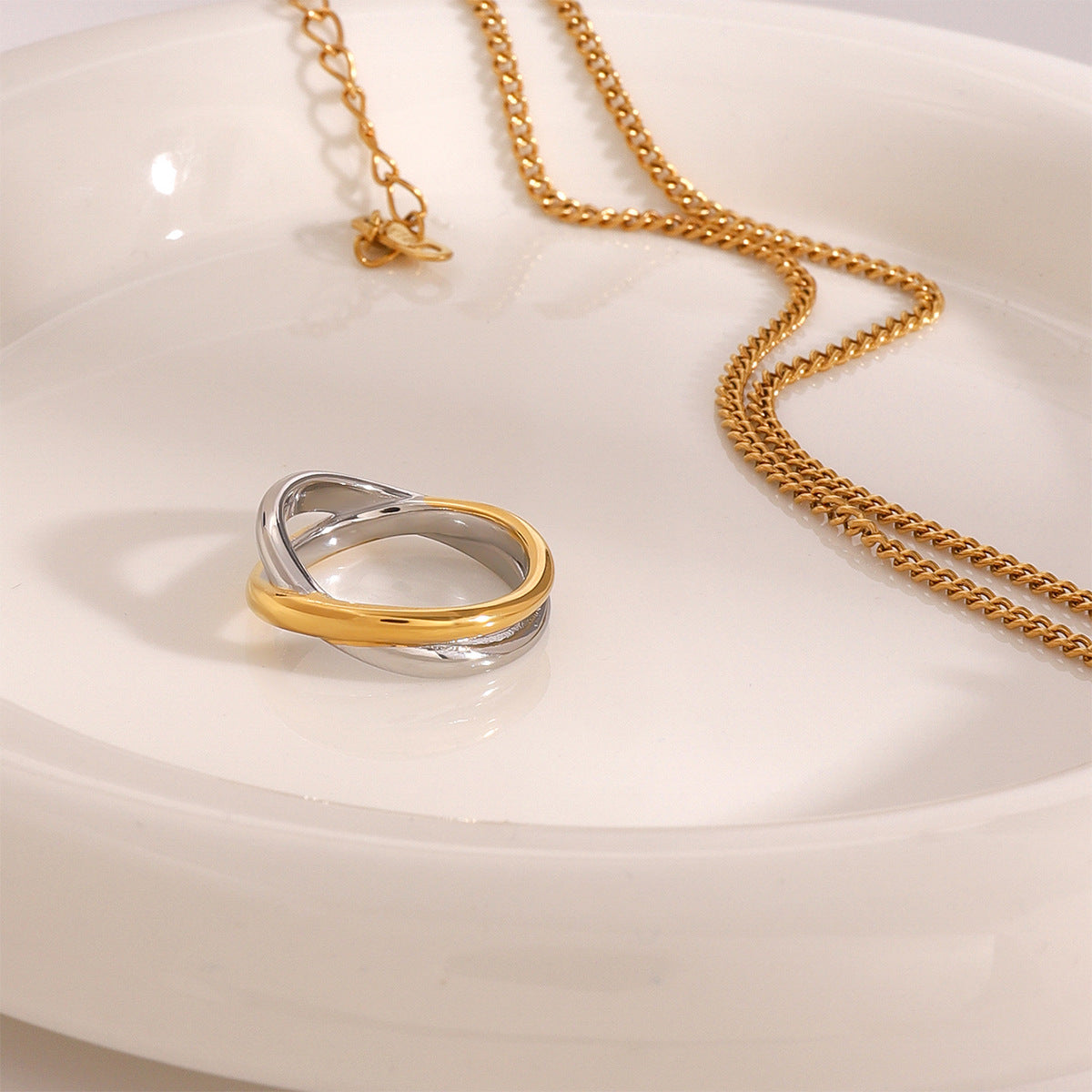 Gold detail crossing a silver-colored stainless steel ring