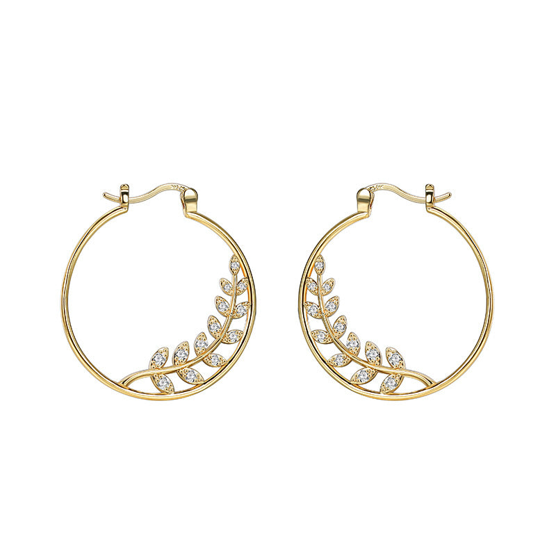 mirrored pair of clear stone leaf hoop earrings on white