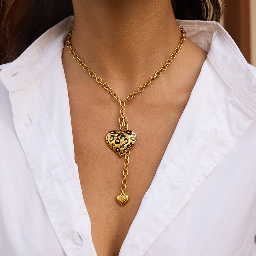 Model wearing long gold-tone heart pendant necklace