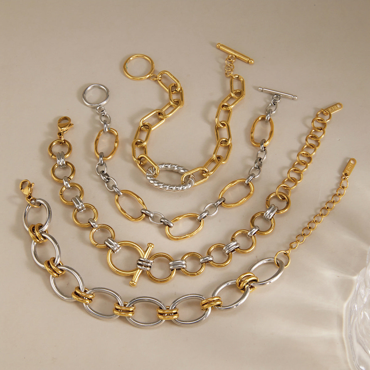 Gold-tone and silver-tone bracelet styles on stone