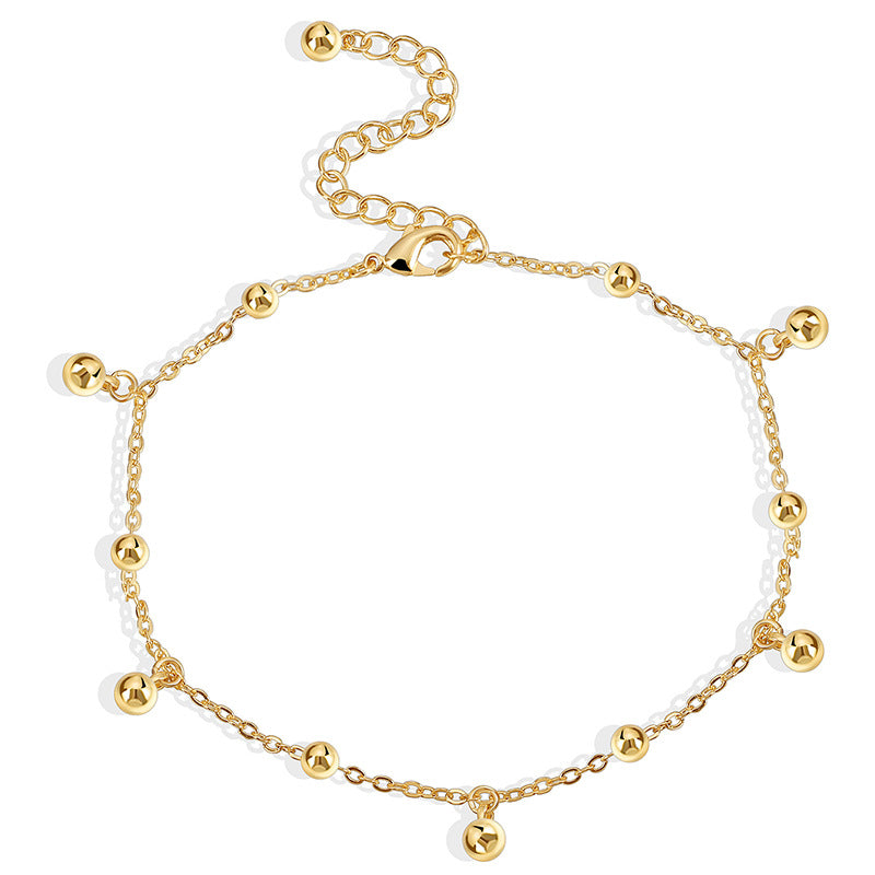 isolated fine-chain anklet with evenly spaced gold beads