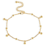 isolated fine-chain anklet with evenly spaced gold beads