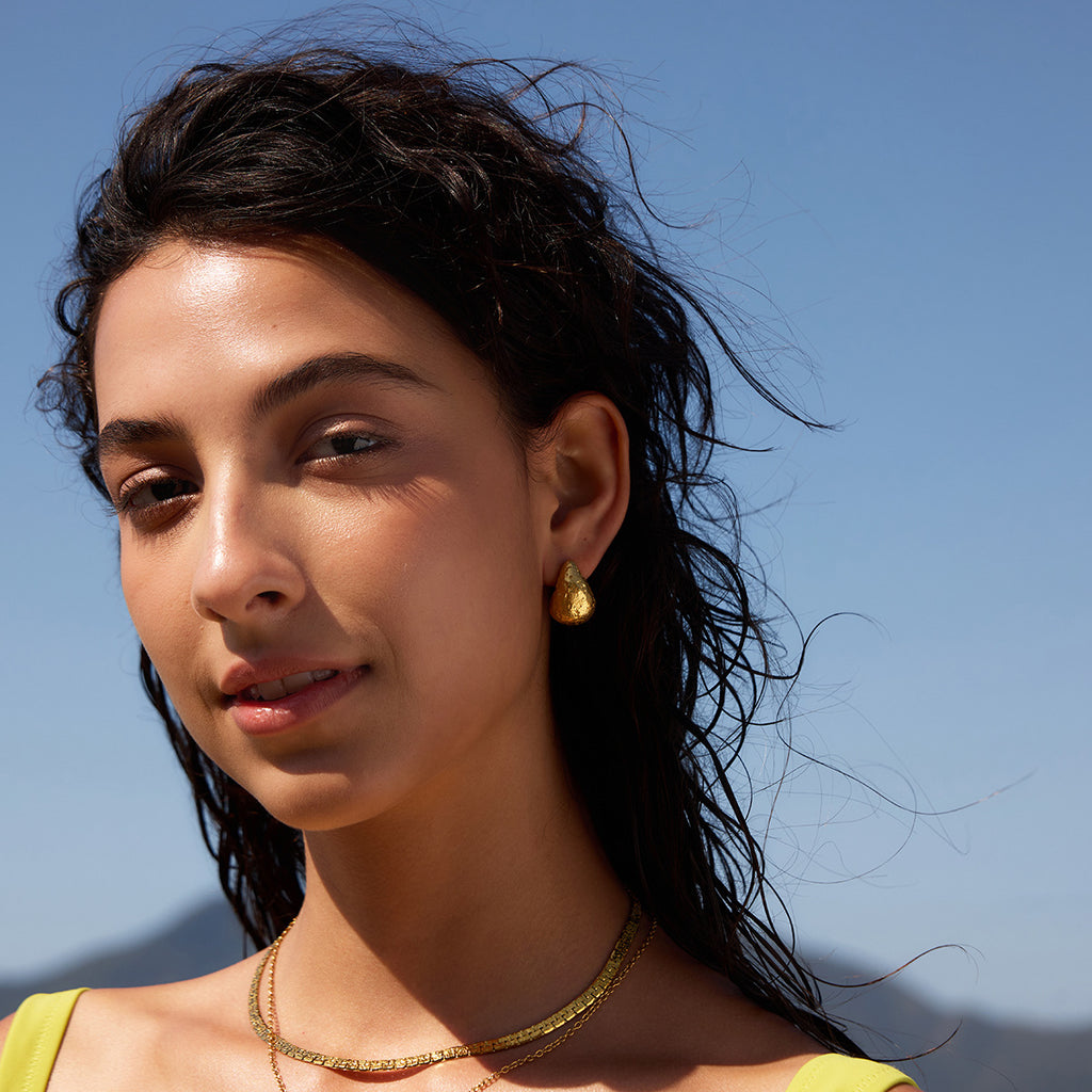 Gold-tone textured studs styled outdoors