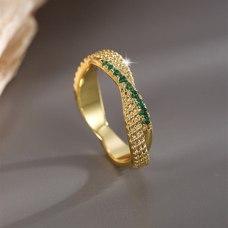 angled green-stone crossover ring on a dark surface