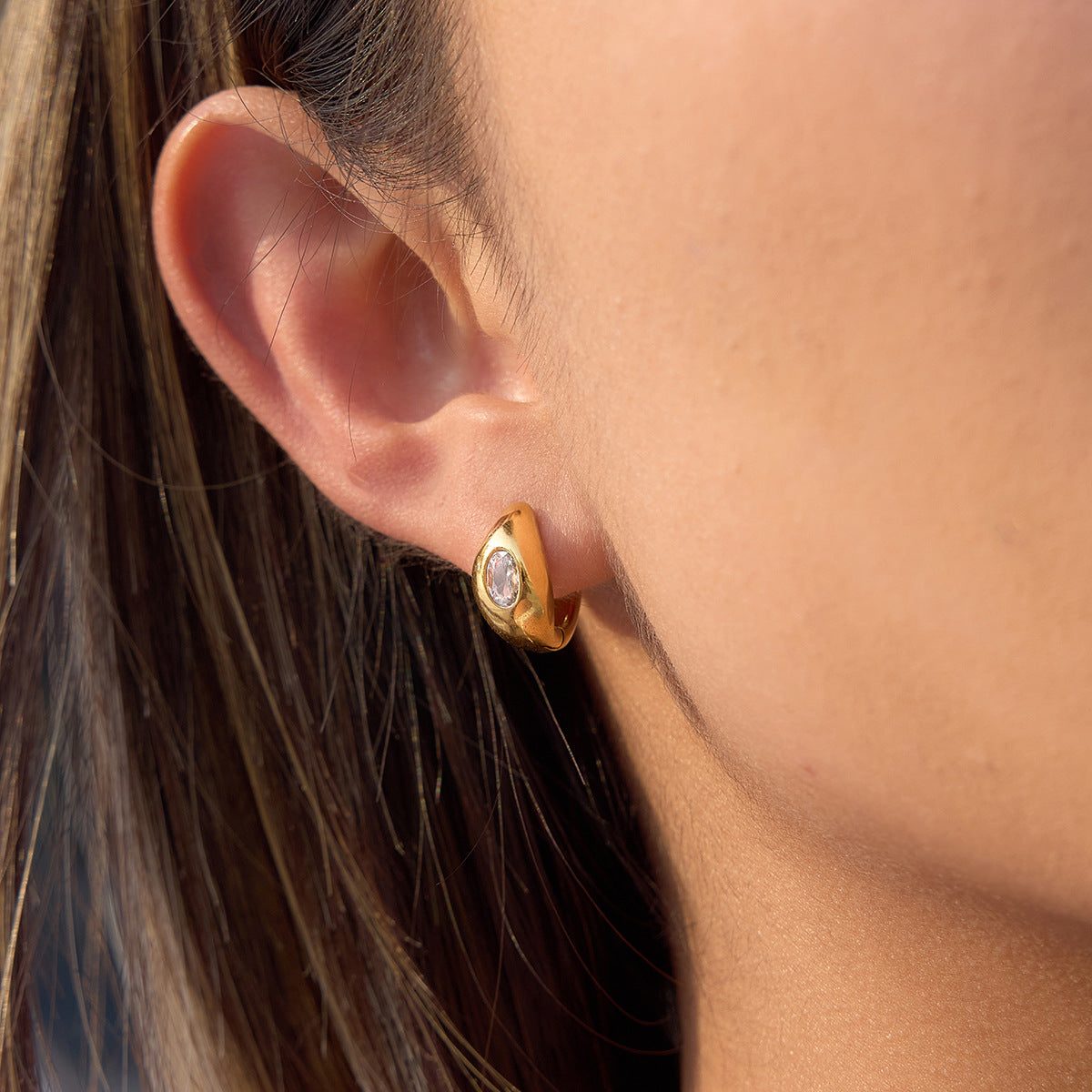 side view of sculptural teardrop stone huggie earring