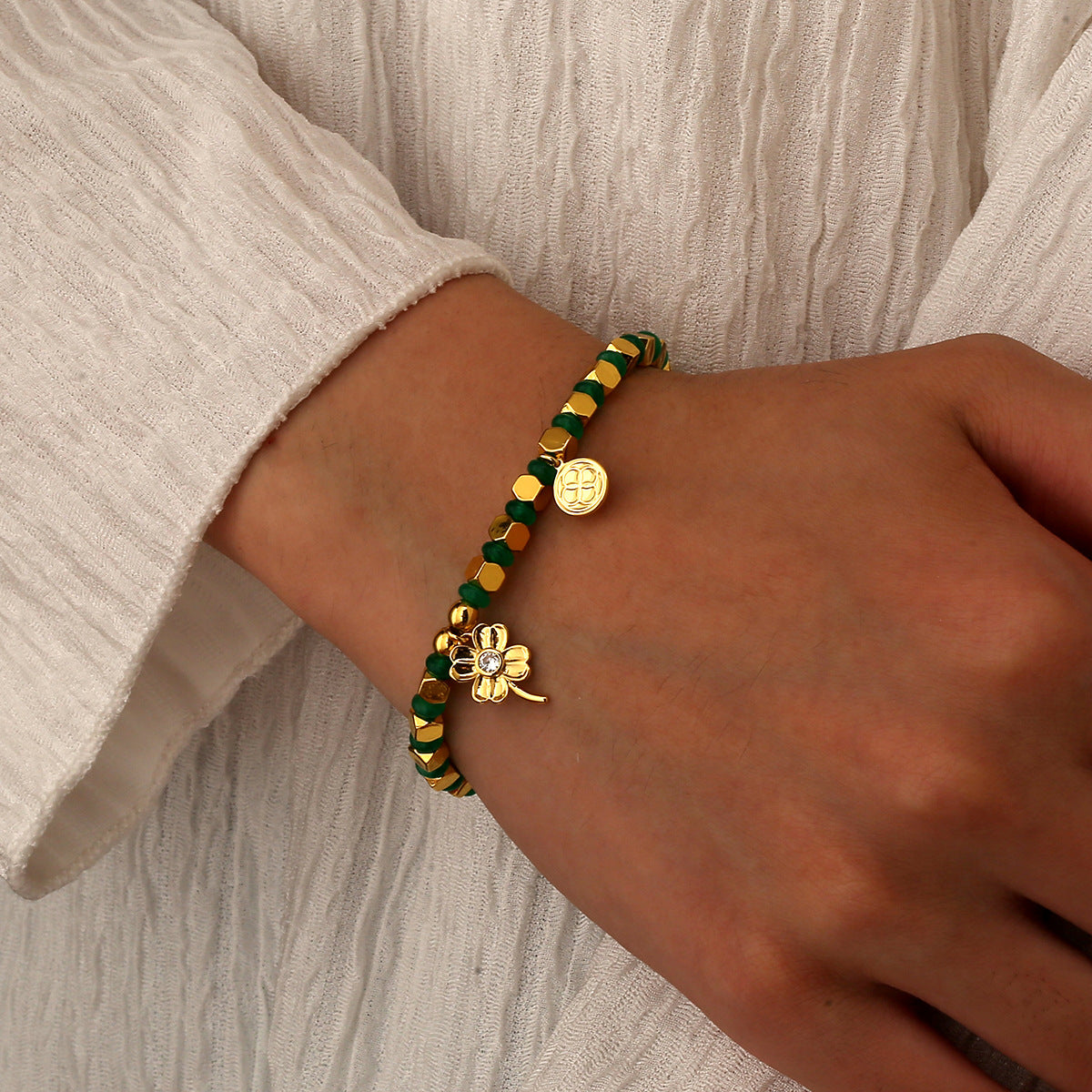 model wearing a green bead four-leaf clover charm bracelet