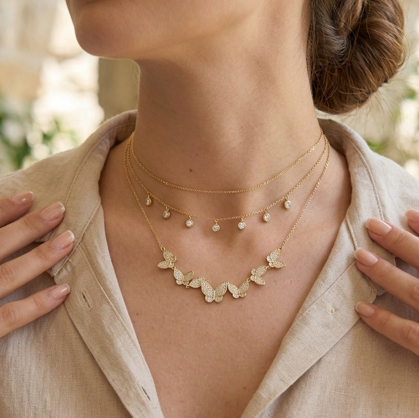 Butterfly necklace worn with two additional necklaces