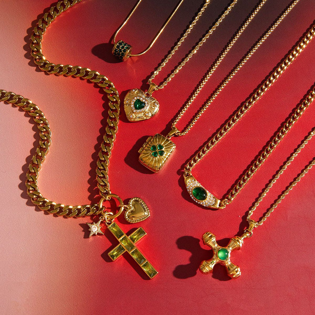 Green accent stainless steel pendant necklace collection arranged on red