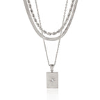 Front view of silver-color three-strand star tag necklace