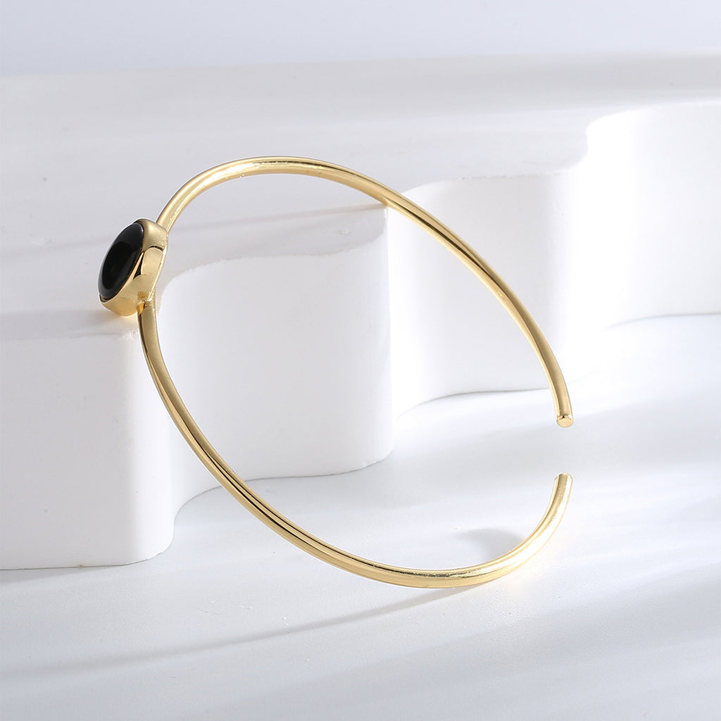 side profile of round black agate bezel on an open bangle