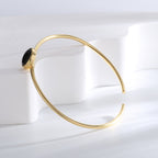 side profile of round black agate bezel on an open bangle