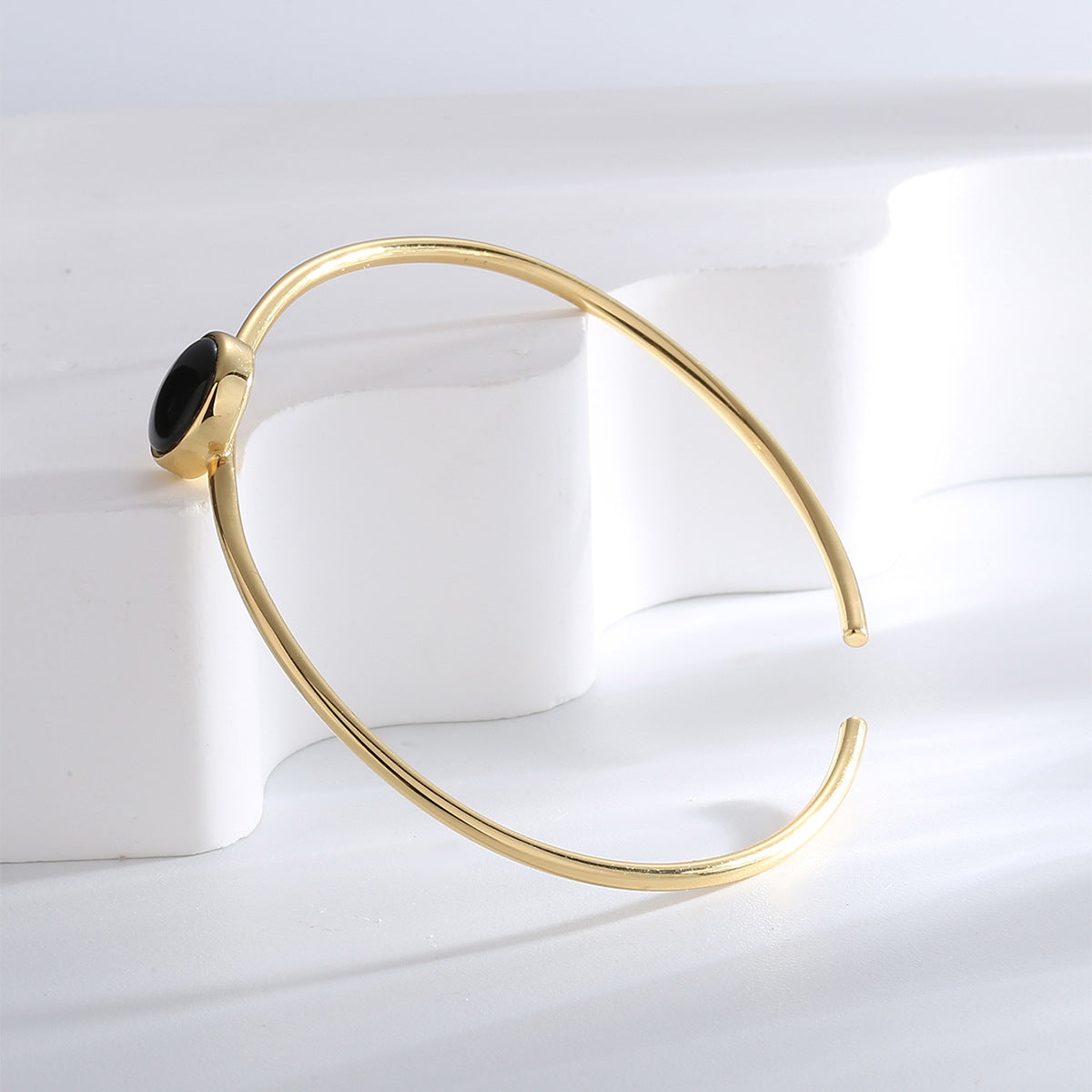 side profile of round black agate bezel on an open bangle