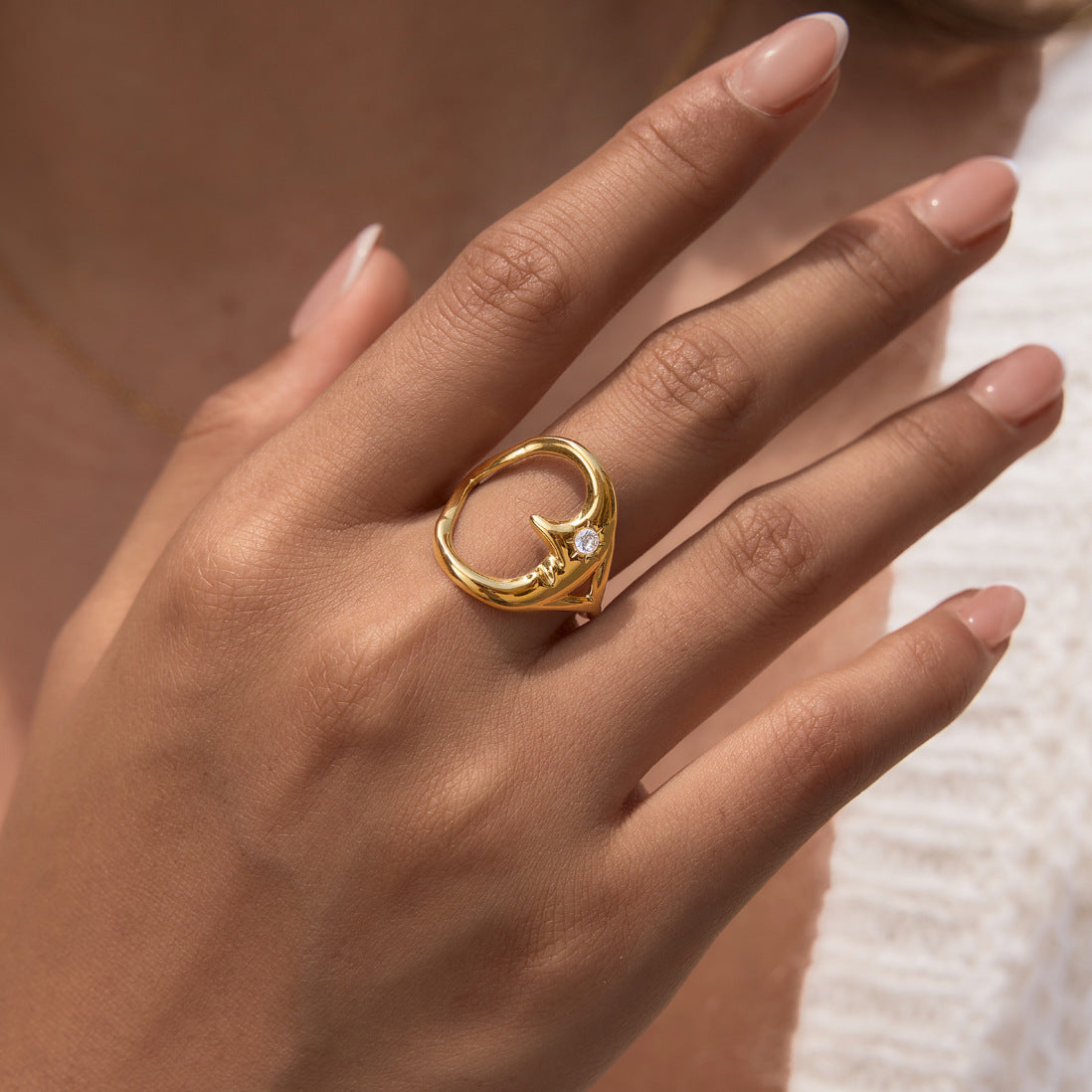 Open crescent-face ring worn on a finger