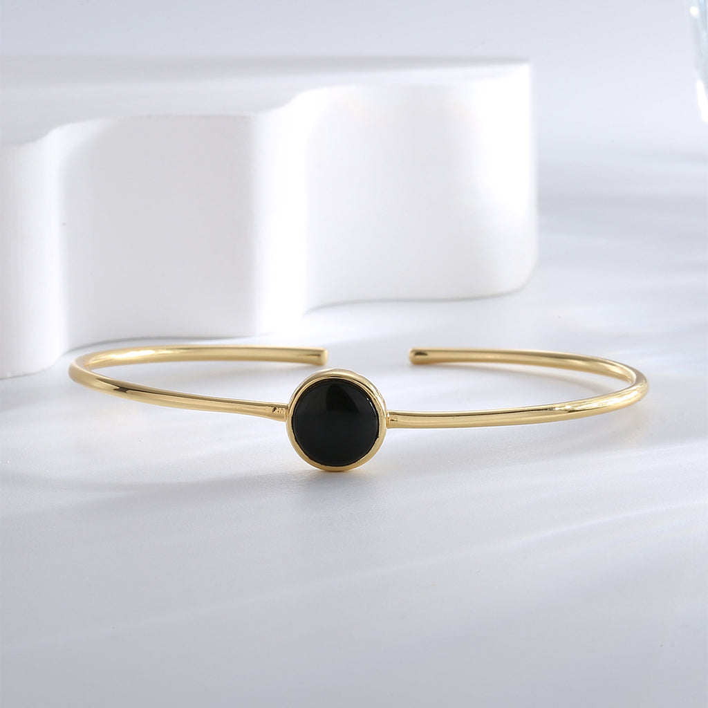 angled front view of black agate cabochon bangle on white