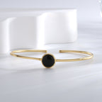 angled front view of black agate cabochon bangle on white