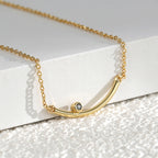 close view of the curved gold plated bar and dark round accent