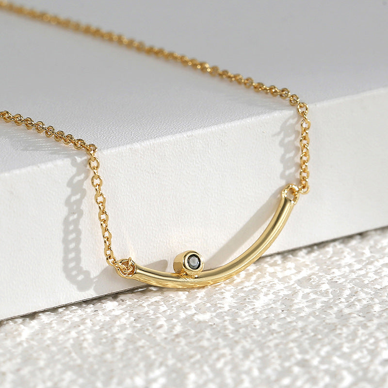 close view of the curved gold plated bar and dark round accent