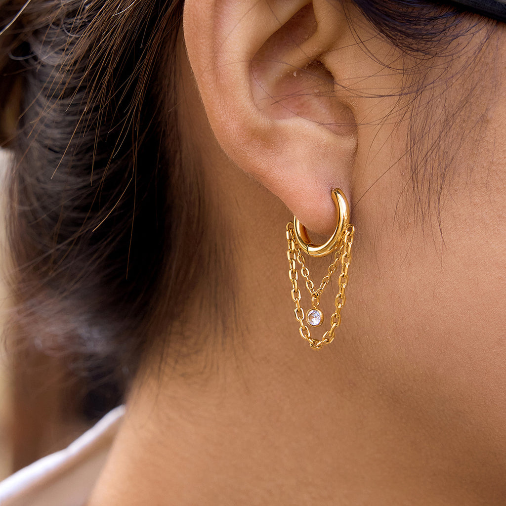 Gold-tone hoop with layered chain loops worn on an ear